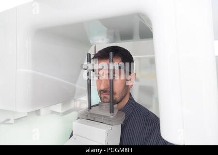 Portrait jeune homme ayant une vue panoramique sur la radiographie numérique de ses dents dans le cabinet dentaire. Banque D'Images