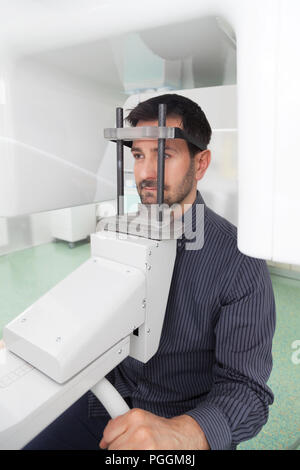 Portrait jeune homme ayant une vue panoramique sur la radiographie numérique de ses dents dans le cabinet dentaire. Banque D'Images