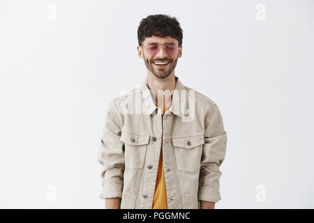 Homme de parti élégant avec barbe en lunettes de soleil et veste trendy t-shirt jaune au sourire et rire de l'amusement et le bonheur de fermer les yeux se sentir insouciante bénéficiant d'une grande dépense de temps Banque D'Images