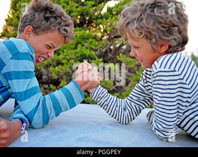 Deux enfants jouant dans le parc armwrestling Banque D'Images