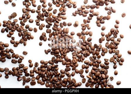 Les grains de café brun éparpillés sur fond blanc Banque D'Images