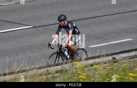 Un homme habillé en lycra cycle rider sur une chaussée double photographié d'en haut. Banque D'Images