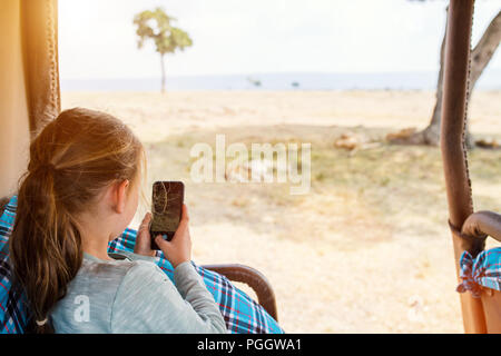 Adorable petite fille au Kenya safari sur commande de jeu de matin en véhicule découvert en observant les lions Banque D'Images