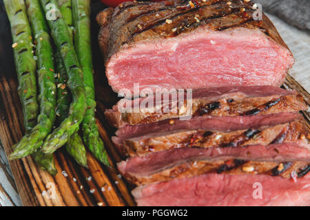 Pavé de boeuf grillé en tranches moyennes rares , les asperges, tomates Banque D'Images