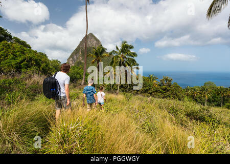De père de famille et enfants en randonnée sur la journée d'été à l'île tropicale de Sainte-Lucie dans les Caraïbes avec belles vues sur la montagne emblématique des Pitons. Banque D'Images
