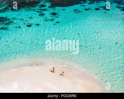 Vue aérienne de drone minuscule île tropicale Mopion sandbar, turquoise de la mer des Caraïbes et une famille avec des enfants à St Vincent et Grenadines Banque D'Images