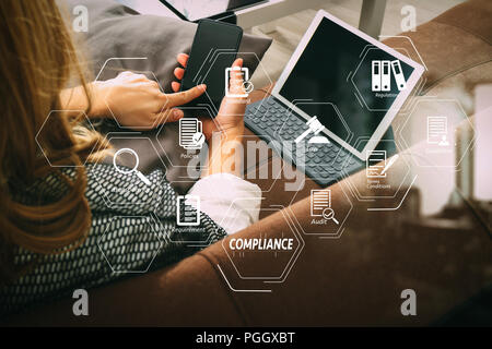 Schéma de la conformité pour les règlements, les lois, les normes, les exigences et l'audit.brunette woman using smart phone et digital tablet computer on sof Banque D'Images