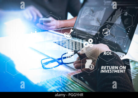 Retour sur investissement RETOUR SUR INVESTISSEMENT indicateur dans le tableau de bord virtuel pour améliorer l'entreprise. Deux collègues discuter et concepteur de site web de données numérique et tablette Banque D'Images