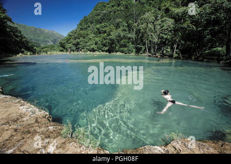 Une femelle dans l'eau froide des bassins d'eau turquoise de Semuc Champey, Guatemala Banque D'Images