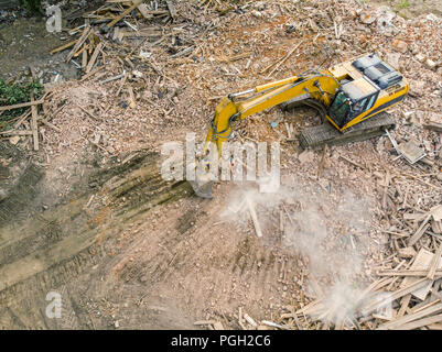 Chargeur pelle au travail de démolition à ruines de l'ancien bâtiment. photo aérienne Banque D'Images