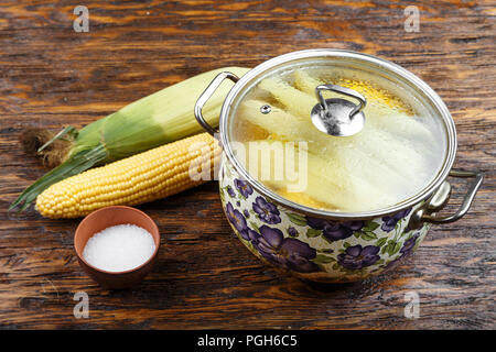 Le maïs cru dans une casserole recouverte d'un couvercle en verre transparent, la cuisson du maïs bouilli les jeunes Banque D'Images