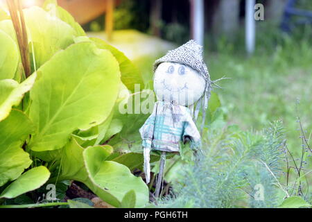 Funny garden gnome debout parmi les fleurs de Nice. Banque D'Images