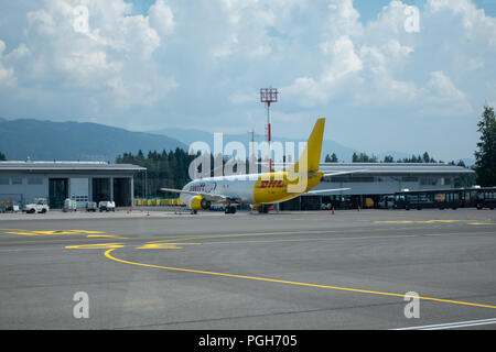 Brnik, Slovenija - 23 août 2018 : Swift Air Boeing B737 jaune avec logo DHL sur la queue à l'aéroport de Ljubljana en attente de chargement sur tarmac. Banque D'Images