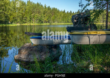 Kayaks amarré sur les rochers de la lac Saimaa en Finlande Banque D'Images