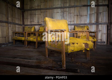 Vieux fauteuil en cuir jaune obsolètes dans abandonner house Banque D'Images