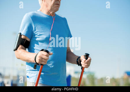 Mid section portrait of senior man la marche nordique avec des poteaux à l'extérieur dans le parc, copy space Banque D'Images