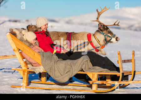 Mère de famille et sa fille à reindeer safari sur journée d'hiver ensoleillée dans le Nord de la Norvège Banque D'Images