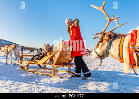 Mère de famille et sa fille à reindeer safari sur journée d'hiver ensoleillée dans le Nord de la Norvège Banque D'Images