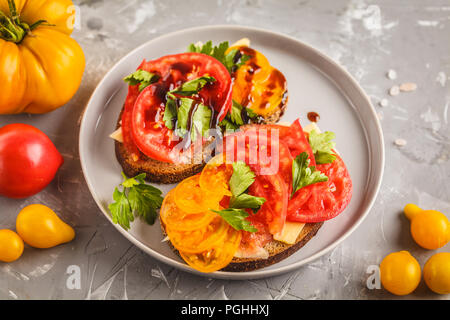 Des sandwichs aux tomates et fromage sur la plaque grise, vue du dessus. Concept de l'alimentation propre. Banque D'Images