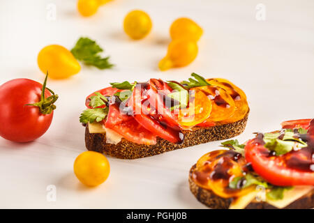 Des sandwichs aux tomates et fromage sur fond blanc, vue du dessus. Concept de l'alimentation propre. Banque D'Images