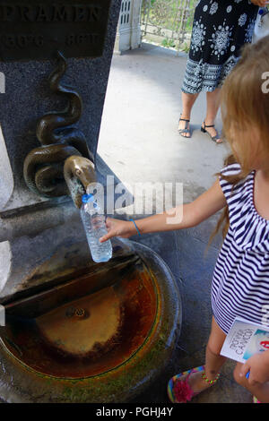 Jeune fille à un minéral spring fountain touchez dans ville thermale Karlovy Vary République Tchèque Banque D'Images