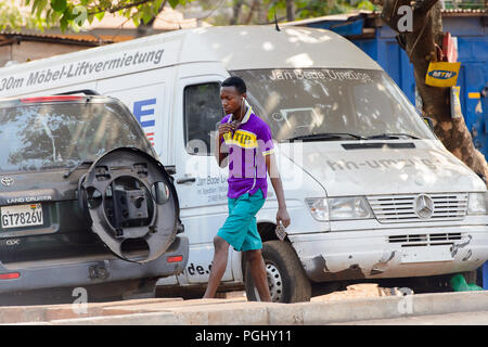 Région du Centre, le GHANA - Jan 17, 2017 : garçon ghanéenne non identifiés à l'écoute de la musique tout en marchant dans le village local. Les gens souffrent de la pauvreté du Ghana en raison Banque D'Images