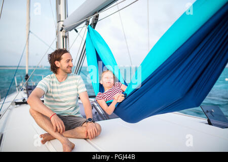 Famille de père et fille mignonne de vous détendre dans le hamac situé sur le voilier en navigation dans la mer ouverte Banque D'Images