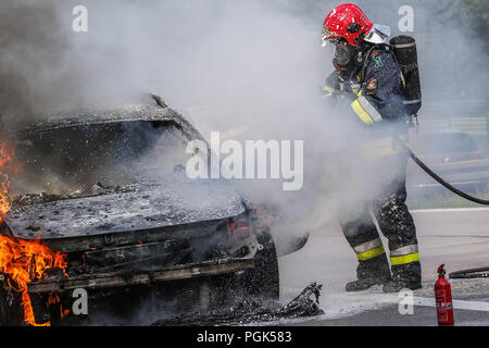 Gdynia, Pologne 27. Août 2018 Feu de voiture sur la S6 - TriCity ringroad à Gdynia. Les pompiers d'État polonais Fire Brigade (Straz) Pozarna sont vus alors qu'essayer de controll fire de Renault Scenic voiture. Voiture a commencé à brûler violemment pendant la conduite. © Vadim Pacajev / Alamy Live News Banque D'Images