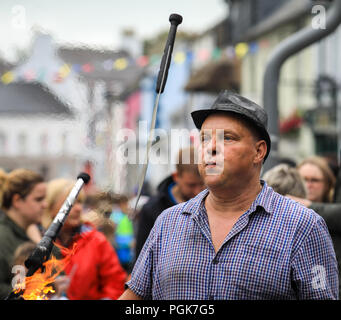 Ballycastle, Irlande du Nord. Lundi 27 Août, 2018. Un artiste de rue jongle avec des couteaux et des torches enflammées à l'Ould Lammas Fair à Ballycastle Le Ould Lammas Fair est la plus ancienne foire de l'Irlande. Le mot Lammas vient de 'la masse' - Pain pain cuit traditionnellement à partir de la première les grains d'automne ont été mis sur l'église à modifier. SSince le 17ème siècle, l'traders affluent sur la juste d'acheter et de vendre des animaux, une tradition qui Crédit : Graham de Alamy Live News Banque D'Images