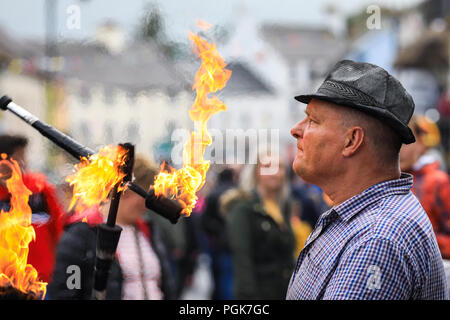 Ballycastle, Irlande du Nord. Lundi 27 Août, 2018. Un artiste de rue jongle avec des torches enflammées à l'Ould Lammas Fair à Ballycastle Le Ould Lammas Fair est la plus ancienne foire de l'Irlande. Le mot Lammas vient de 'la masse' - Pain pain cuit traditionnellement à partir de la première les grains d'automne ont été mis sur l'église à modifier. SSince le 17ème siècle, l'traders affluent sur la juste d'acheter et de vendre des animaux, une tradition qui continue Crédit : Graham de Alamy Live News Banque D'Images