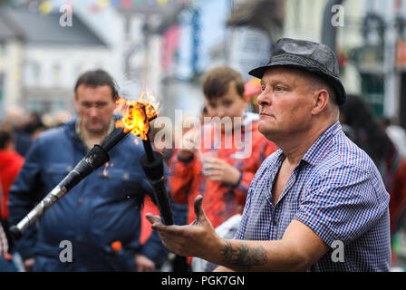 Ballycastle, Irlande du Nord. Lundi 27 Août, 2018. Un artiste de rue jongle avec des torches enflammées à l'Ould Lammas Fair à Ballycastle Le Ould Lammas Fair est la plus ancienne foire de l'Irlande. Le mot Lammas vient de 'la masse' - Pain pain cuit traditionnellement à partir de la première les grains d'automne ont été mis sur l'église à modifier. SSince le 17ème siècle, l'traders affluent sur la juste d'acheter et de vendre des animaux, une tradition qui continue Crédit : Graham de Alamy Live News Banque D'Images