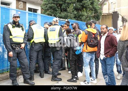 Londres, Royaume-Uni. 27 août 2018. Arrêt de la police se sont réunis et recherchez les jeunes hommes sur le deuxième jour de Notting Hill Carnival. Le deuxième jour de la Notting Hill Carnival a été mis sous un ordre de l'article 60 pour l'ensemble de la journée. L'article 60 donne à la police le pouvoir de fouiller des personnes.Credit : Claire Doherty/Alamy Live News Banque D'Images