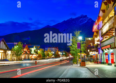 Vue sur la rue de la célèbre Avenue Banff au crépuscule du temps. Banff est une ville de villégiature et l'une des plus populaires destinations touristiques. Banque D'Images