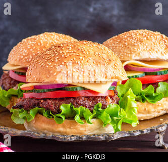 Burger avec escalope frite, fromage et légumes dans une partie de la farine de blé bun, Close up Banque D'Images