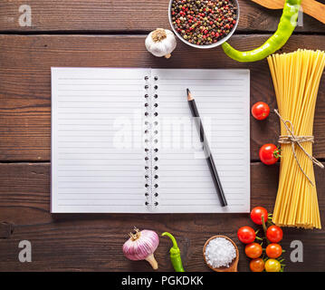 Ordinateur portable ouvert dans une ligne vide avec des draps blancs et un crayon en bois noir, les ingrédients pour faire des pâtes, vue du dessus Banque D'Images