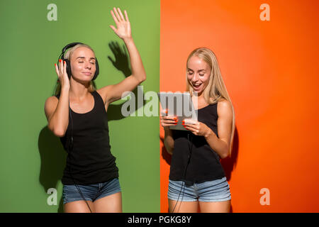 Photo de deux jeunes femmes heureux regardant la caméra et en maintenant les ordinateurs portables à studio. Banque D'Images