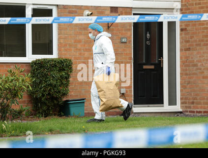 Un agent de police forensic en dehors d'une propriété sur la route Northdown à Solihull, où une enquête pour meurtre a été lancé après qu'une mère et sa fille âgée de 49 et 22 ont été poignardés à mort. Banque D'Images