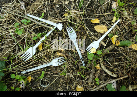 Les déchets plastiques sur la nature de l'herbe pousse. Fourche en plastique plastique.table. Banque D'Images