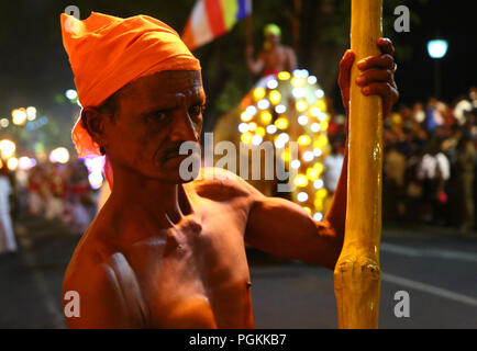 Le Sri Lanka. Août 25, 2018. Un porteur de flambeau des marches en face de la Buddhist Temple de la dent, au cours de l'Esala Perahera festival à l'ancienne capitale de la colline de Kandy, quelques 116 km de Colombo le 25 août 2018. Le festival comporte un cortège de nuit, danseurs de Kandy aménagés, incendie des musiciens traditionnels, les artistes interprètes ou exécutants et les éléphants incendie acrobatique, rassemblant des milliers de touristes et des spectateurs de partout dans l'île. Credit : Pradeep Dambarage/Pacific Press/Alamy Live News Banque D'Images