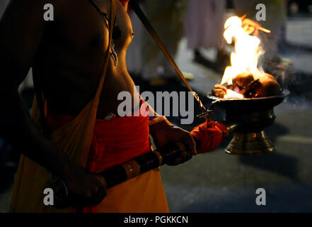 Le Sri Lanka. Août 25, 2018. Un porteur de flambeau des marches en face de la Buddhist Temple de la dent, au cours de l'Esala Perahera festival à l'ancienne capitale de la colline de Kandy, quelques 116 km de Colombo le 25 août 2018. Le festival comporte un cortège de nuit, danseurs de Kandy aménagés, incendie des musiciens traditionnels, les artistes interprètes ou exécutants et les éléphants incendie acrobatique, rassemblant des milliers de touristes et des spectateurs de partout dans l'île. Credit : Pradeep Dambarage/Pacific Press/Alamy Live News Banque D'Images