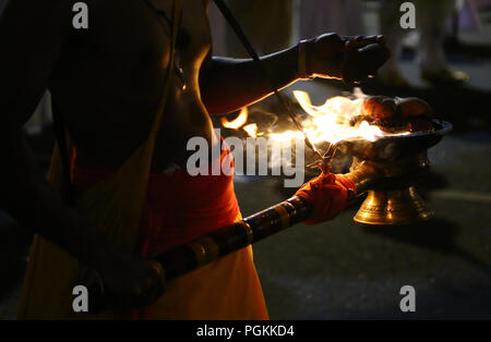 Le Sri Lanka. Août 25, 2018. Un porteur de flambeau des marches en face de la Buddhist Temple de la dent, au cours de l'Esala Perahera festival à l'ancienne capitale de la colline de Kandy, quelques 116 km de Colombo le 25 août 2018. Le festival comporte un cortège de nuit, danseurs de Kandy aménagés, incendie des musiciens traditionnels, les artistes interprètes ou exécutants et les éléphants incendie acrobatique, rassemblant des milliers de touristes et des spectateurs de partout dans l'île. Credit : Pradeep Dambarage/Pacific Press/Alamy Live News Banque D'Images