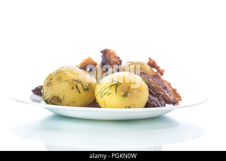 Les jeunes de pommes de terre bouillies avec lard grillé sur une plaque sur un fond blanc Banque D'Images