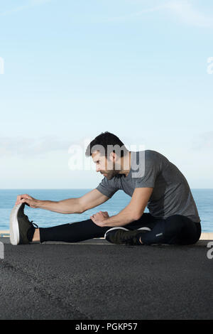 Runner s'étend de la jambe sur l'espace de plancher pour le texte Banque D'Images