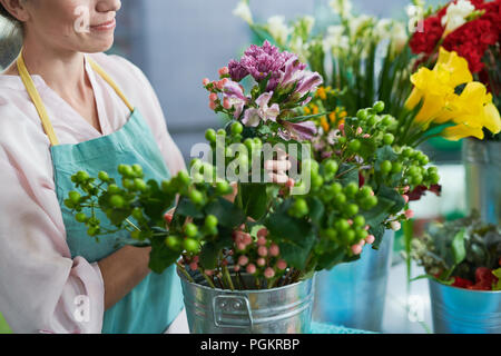 Jeune femme méconnaissable arranging flowers in shop Banque D'Images