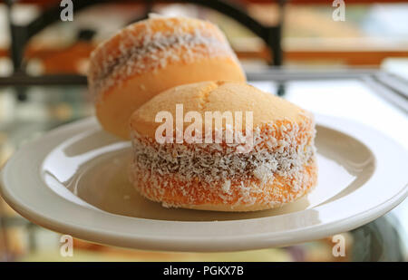 Fermé alfajores de bonbons, d'Amérique latine traditionnelle du lait sucré cookies remplissage servi sur plaque blanche Banque D'Images