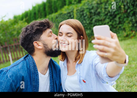 Transmission de blonde-haired woman avec son homme selfies Banque D'Images