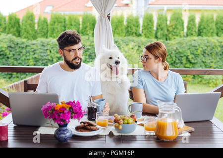 Couple travaillant sur l'entreprise familiale pendant le petit-déjeuner à la maison Banque D'Images