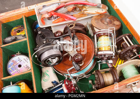 Une boîte en bois contenant une sélection de leurres de pêche en mer, fixe-tiroir et multiplicateur de bobines, bobines de rechange et de lignes. À partir d'une collection de la pêche tackl Banque D'Images