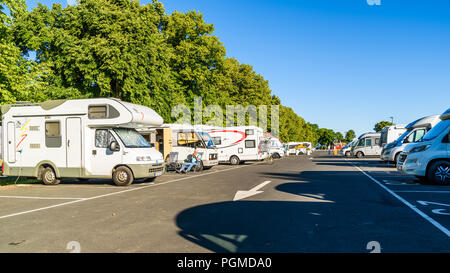 Granna, Suède - 2 juillet 2018 : Espace Camping-cars en stationnement sur zone avec un matin d'été ordinaire. Homme assis au soleil à l'extérieur d'un camping-car. Banque D'Images