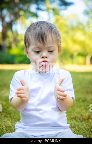 Portrait of Cute petit garçon avec le syndrome de jouer dans la nature Banque D'Images